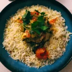 Slow cooker chicken karahi, served on a bed of pilau rice and garnished with fresh coriander